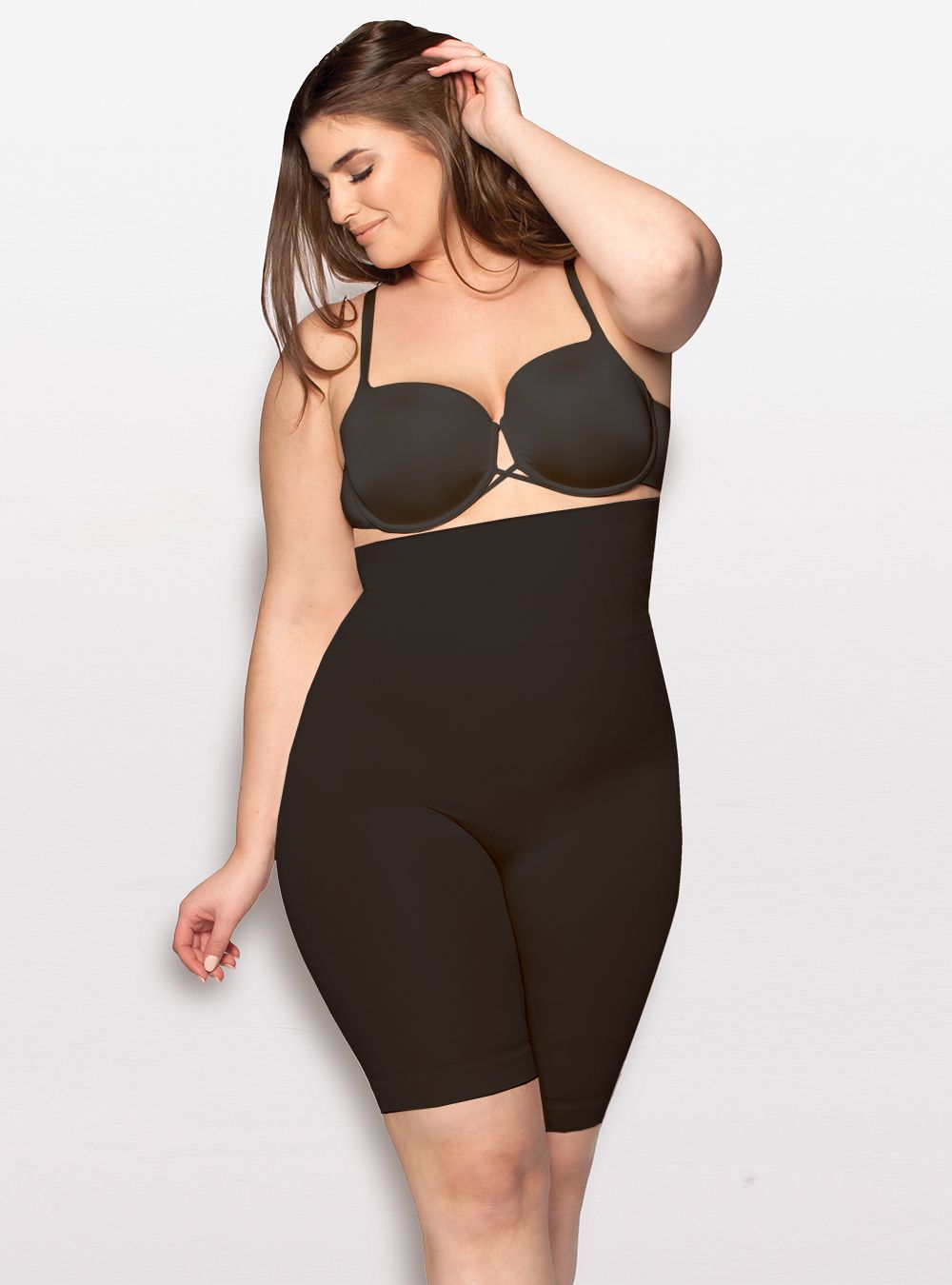 A plus size woman is wearing a black bra and black shorts.