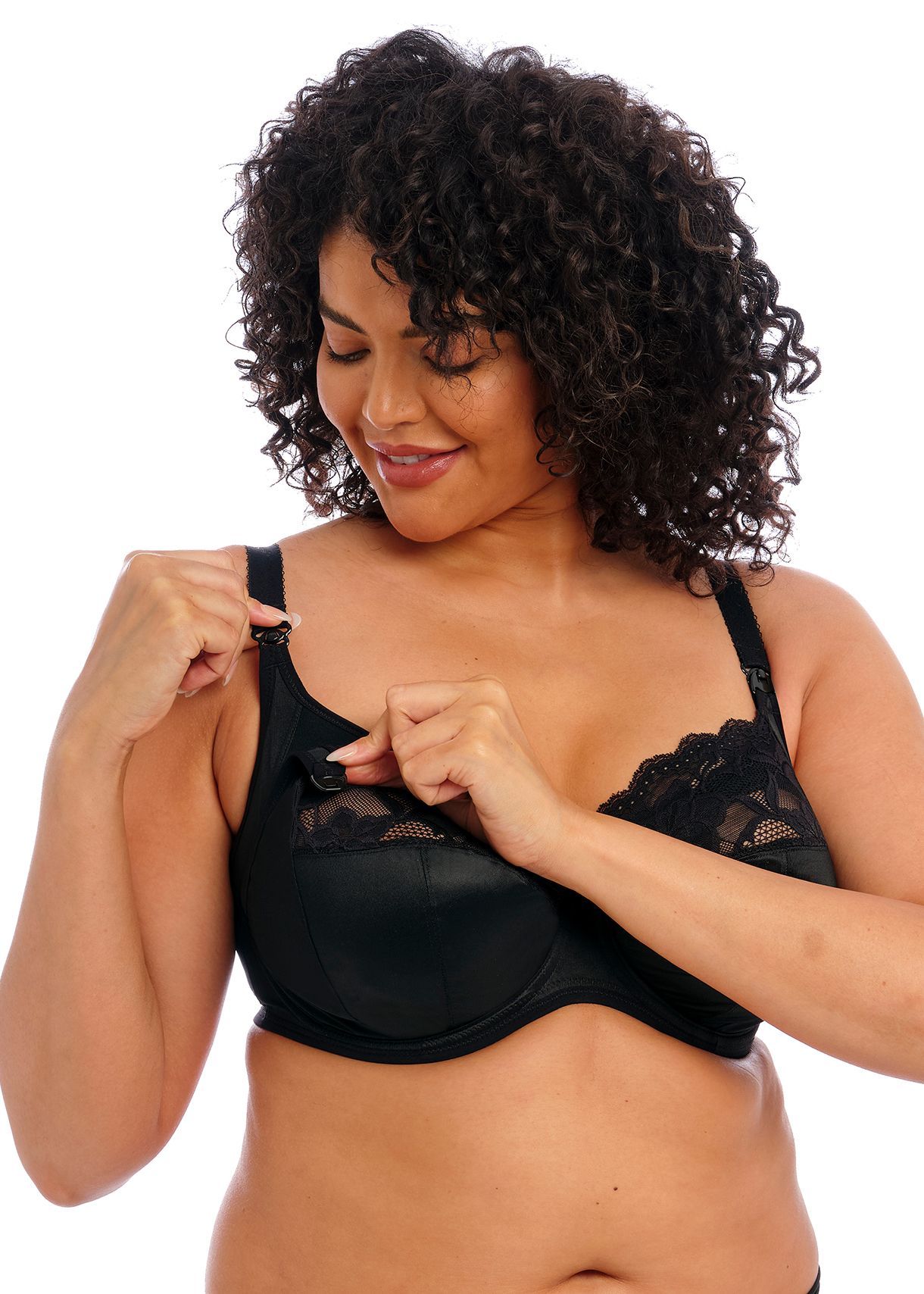 A woman with curly hair is wearing a black bra.