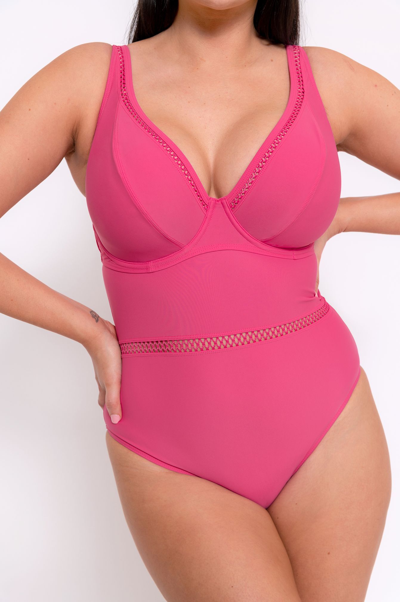 A woman is wearing a pink one piece swimsuit.