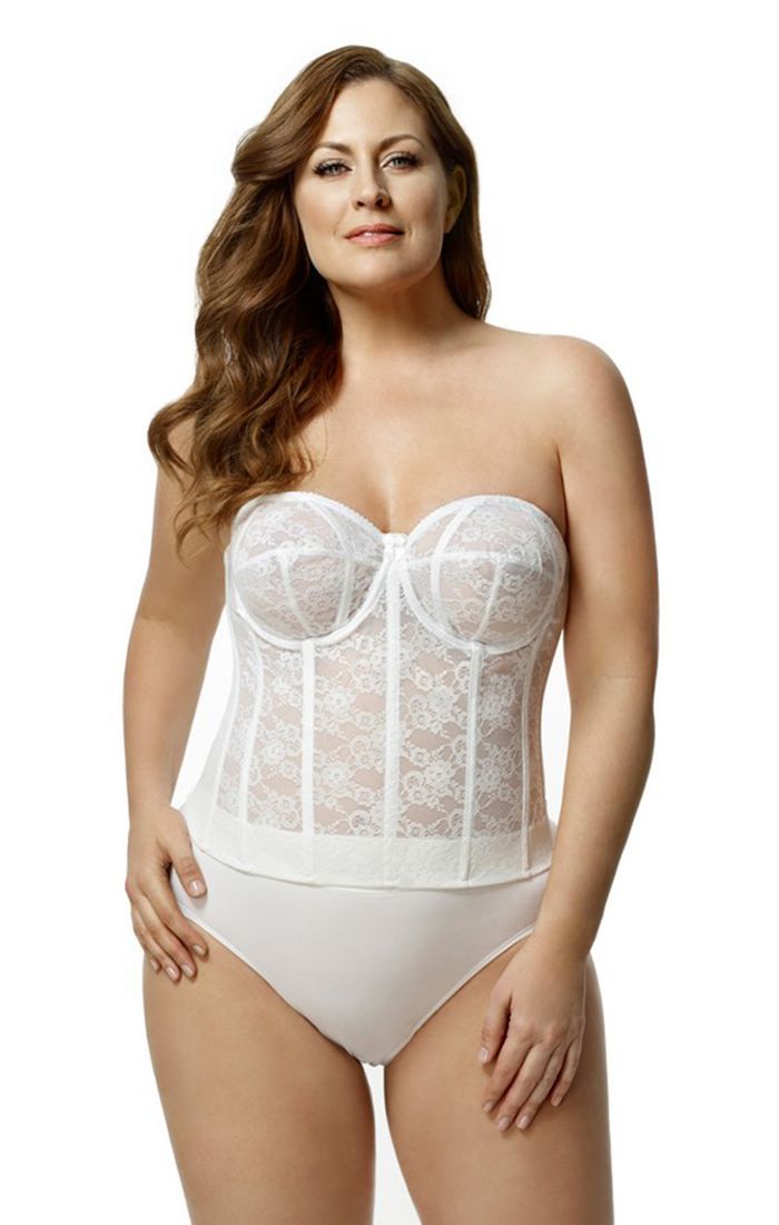 A plus size woman is wearing a white strapless corset and white underwear.