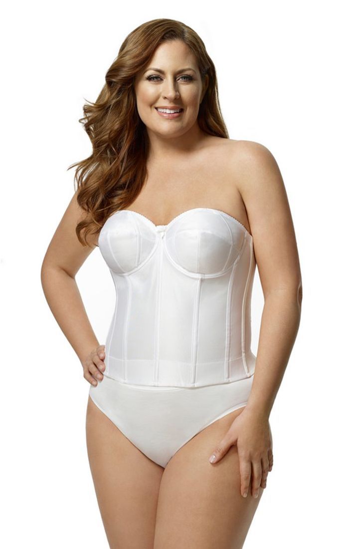 A plus size woman is wearing a white strapless corset and white underwear.