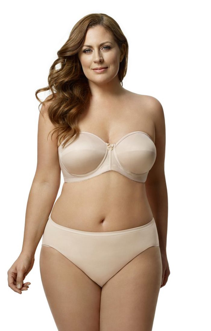 A woman is wearing a strapless bra and panties.