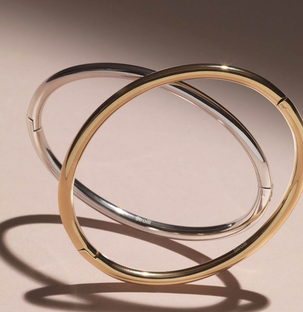 Un primo piano di un braccialetto d'oro e d'argento su un tavolo