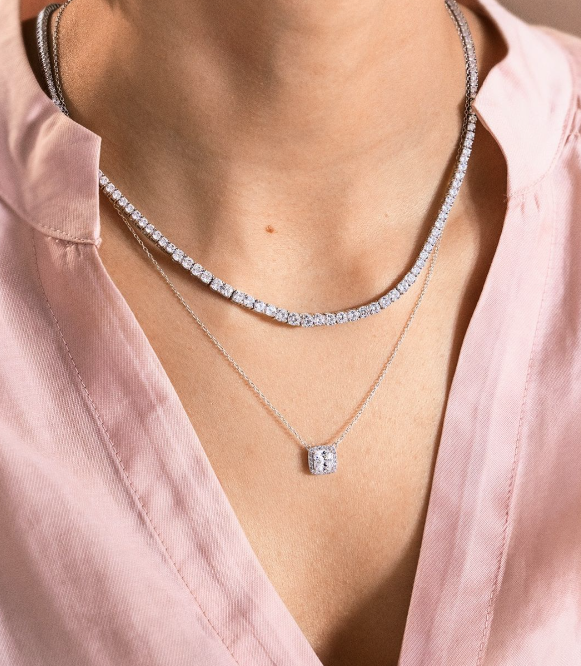 Un primo piano di una donna che indossa due collane