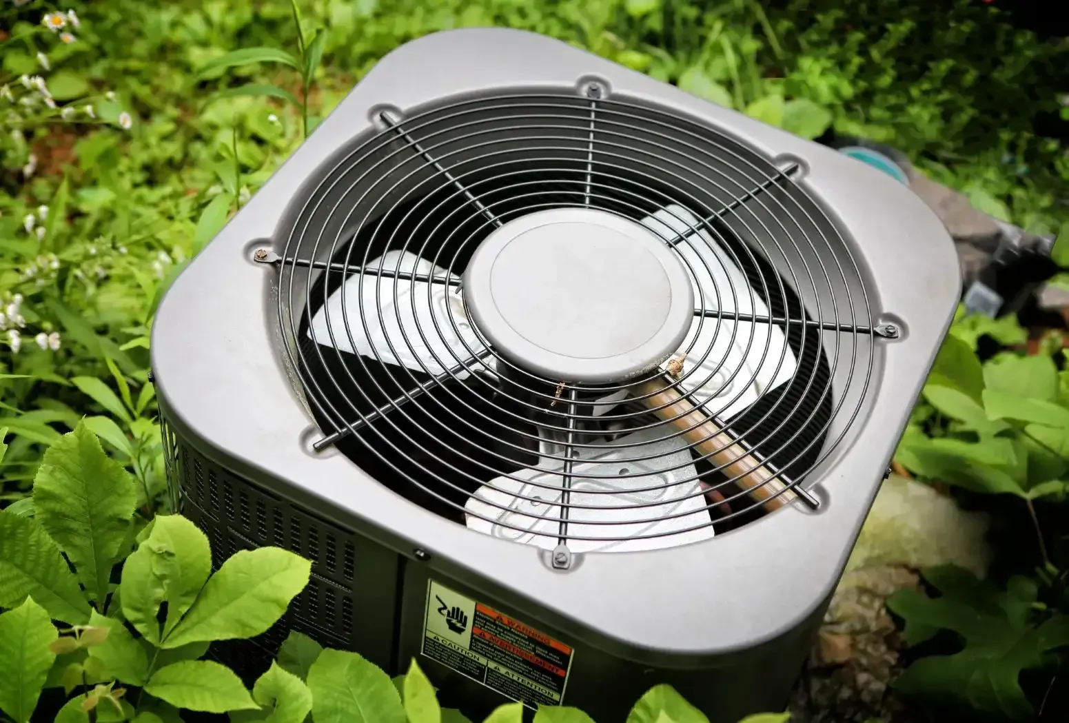 A fan is sitting in the middle of a lush green garden.