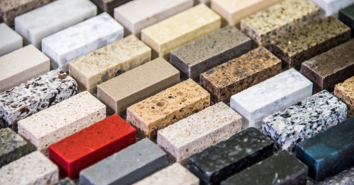 Six rows of evenly spaced samples of granite and quartz countertop materials, all in different colors and compositions.