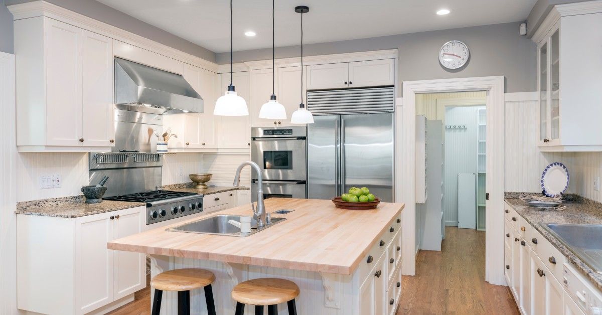 A bright, modern kitchen with white cabinets and light colored countertops.