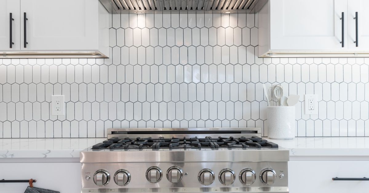 A large oven in a residential kitchen. The surrounding countertop is granite and the backsplash is made of white tiles.