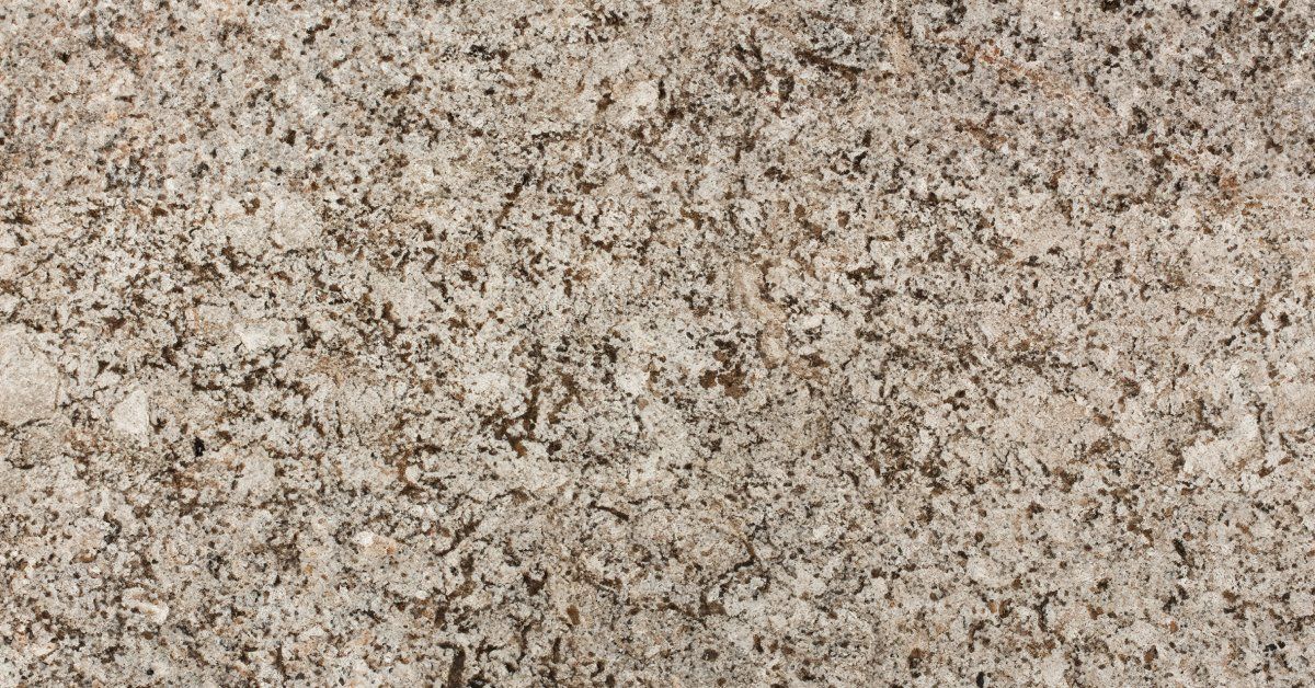 A close-up of a granite countertop surface that has scattered flecks of dark brown, tan, white, and black.
