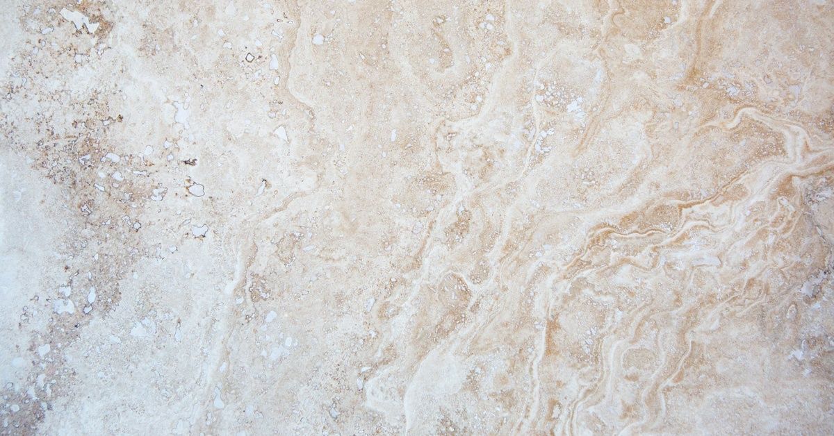 The surface of a brightly lit quartz countertop. The veining in the stone is a mixture of white and 