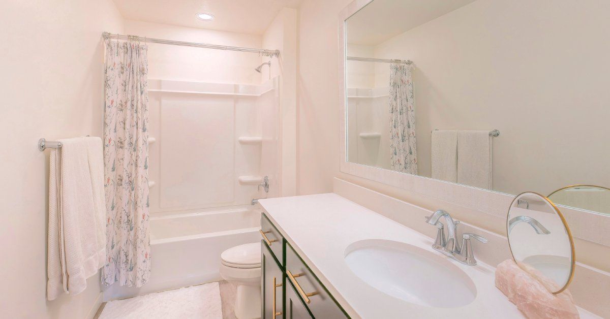A bathroom that is mostly pink aside from a solid surface countertop that is light enough to blend in seamlessly.