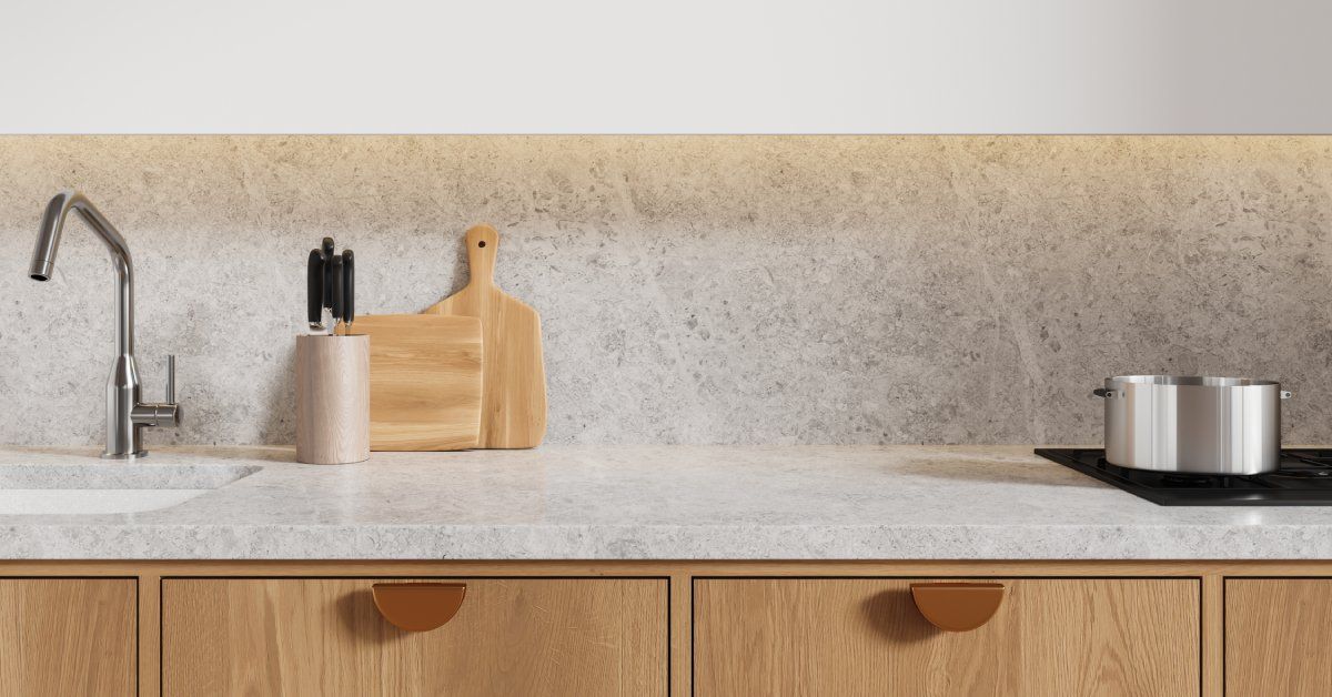A kitchen with white quartz countertops and walls. The small drawers below the counter are wooden.