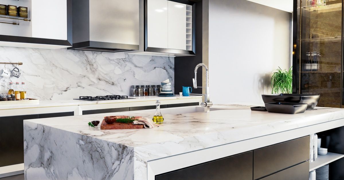A quartz countertop with a waterfall edge installed on an island in the middle of a modern kitchen.