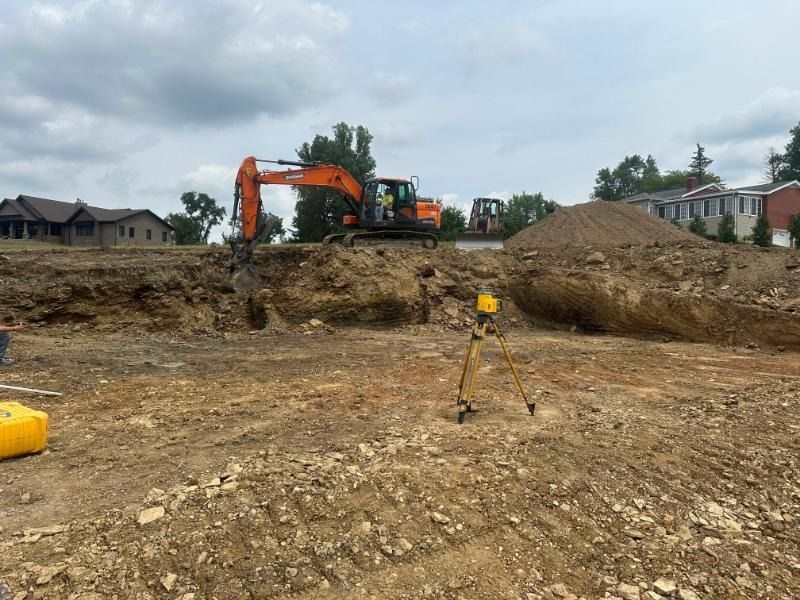 A construction site with a lot of dirt and a tractor in the background.