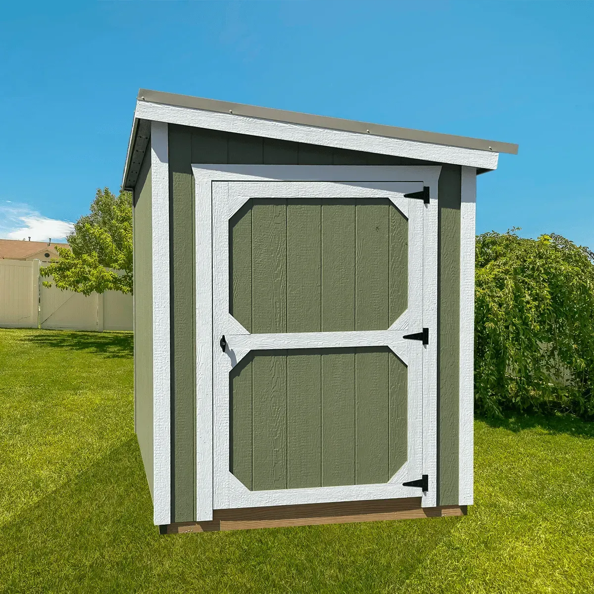 Green storage shed with white trim in a backyard.