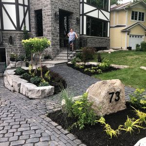 Front yard landscape with a large rocks and lockstone walkway.