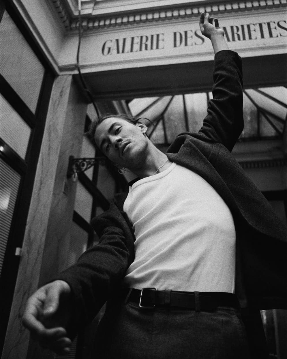 Man in a white shirt and dark jacket raises arm; 