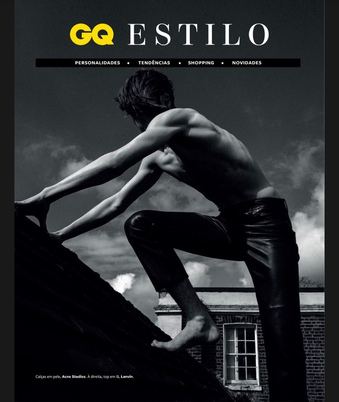 Man climbing a rooftop in black leather pants. GQ Estilo cover in black and white.