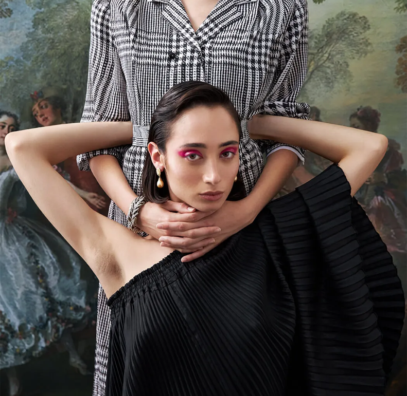 Woman in black dress, arms up, hands around neck. Another person in plaid shirt. Baroque painting background.