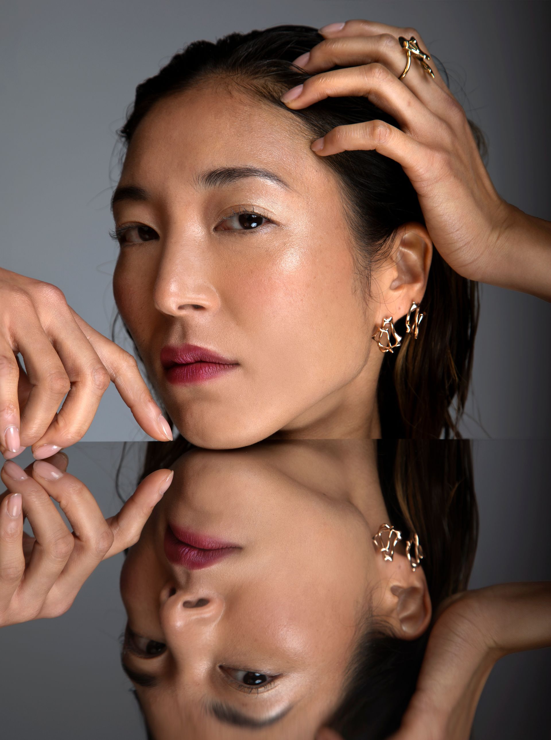 Woman with wet skin and jewelry, mirrored reflection.