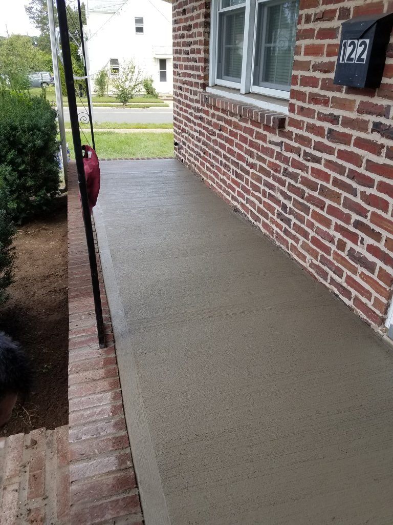 Brick house with a new concrete porch.