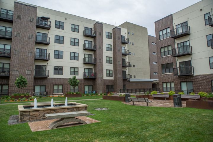 A large apartment building with cars parked in front of it.