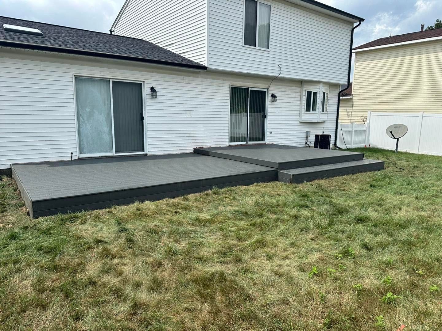 There is a patio in the backyard of a house.