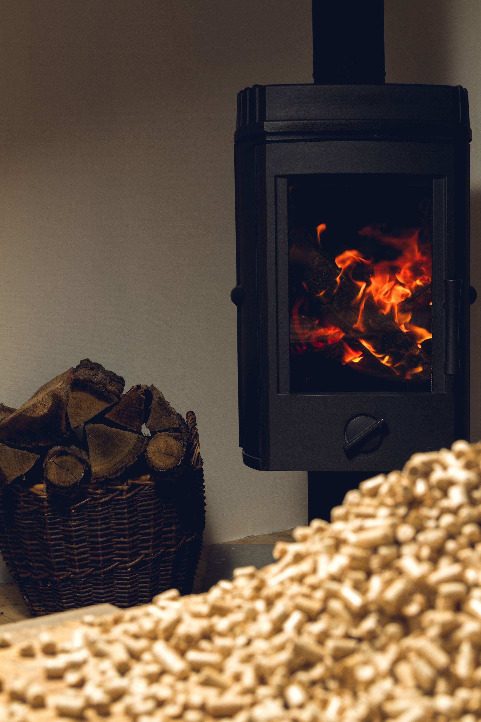 There is a pile of wood pellets next to a fireplace.