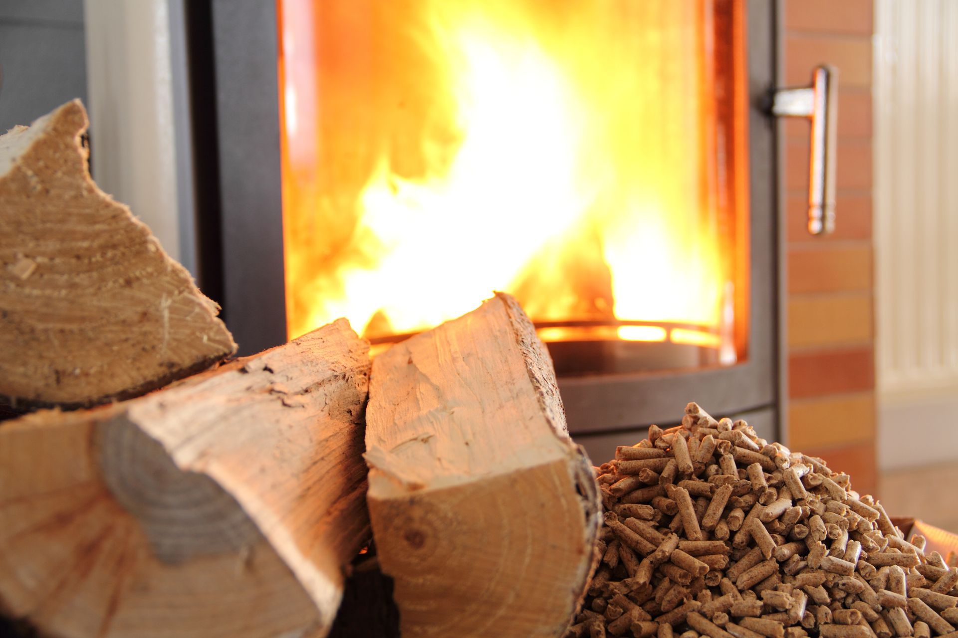 A pile of wood and pellets in front of a fireplace.