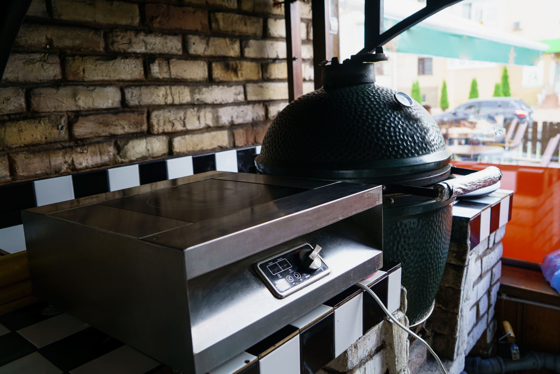 A barbecue grill is cooking meat on a patio.