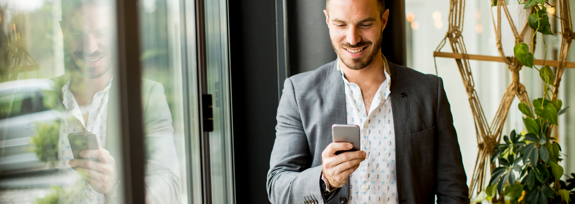 Picture of a businessperson checking a mobile phone and looking delighted 

