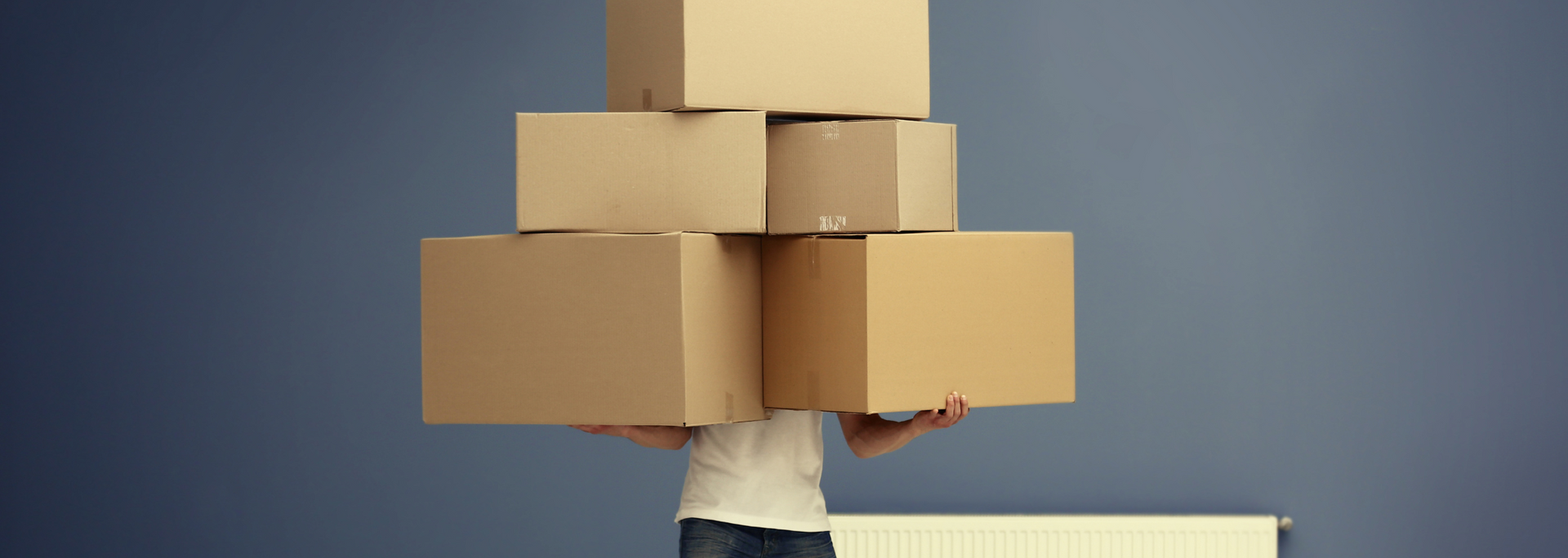 Picture of someone holding loads of boxes, clumsily