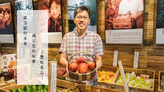 A man is holding a basket of apples in a store.