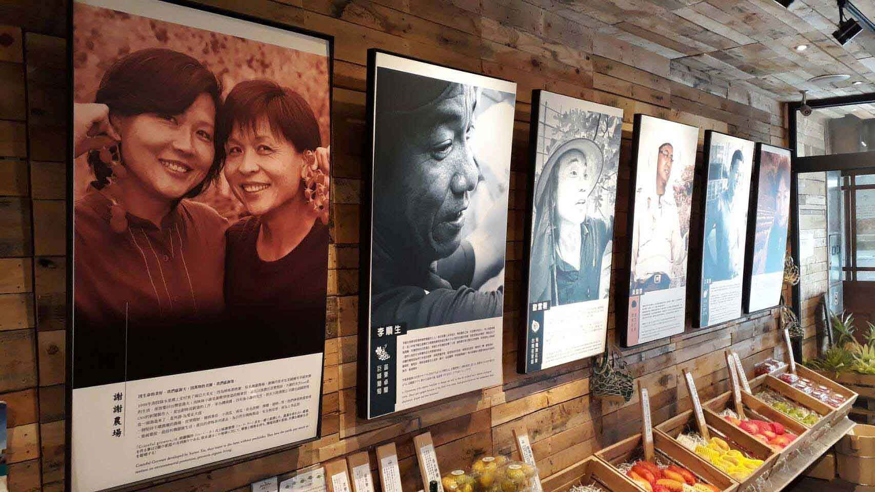 A row of pictures of people are hanging on a wooden wall.