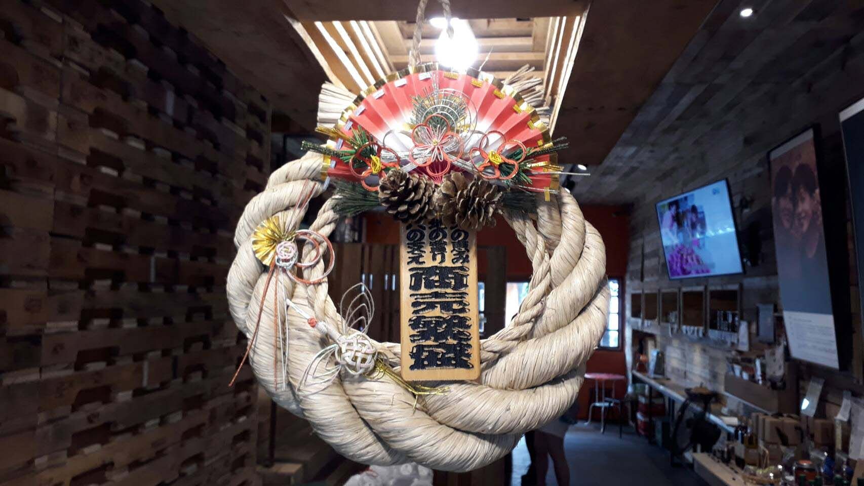 A large rope wreath is hanging from the ceiling in a room.