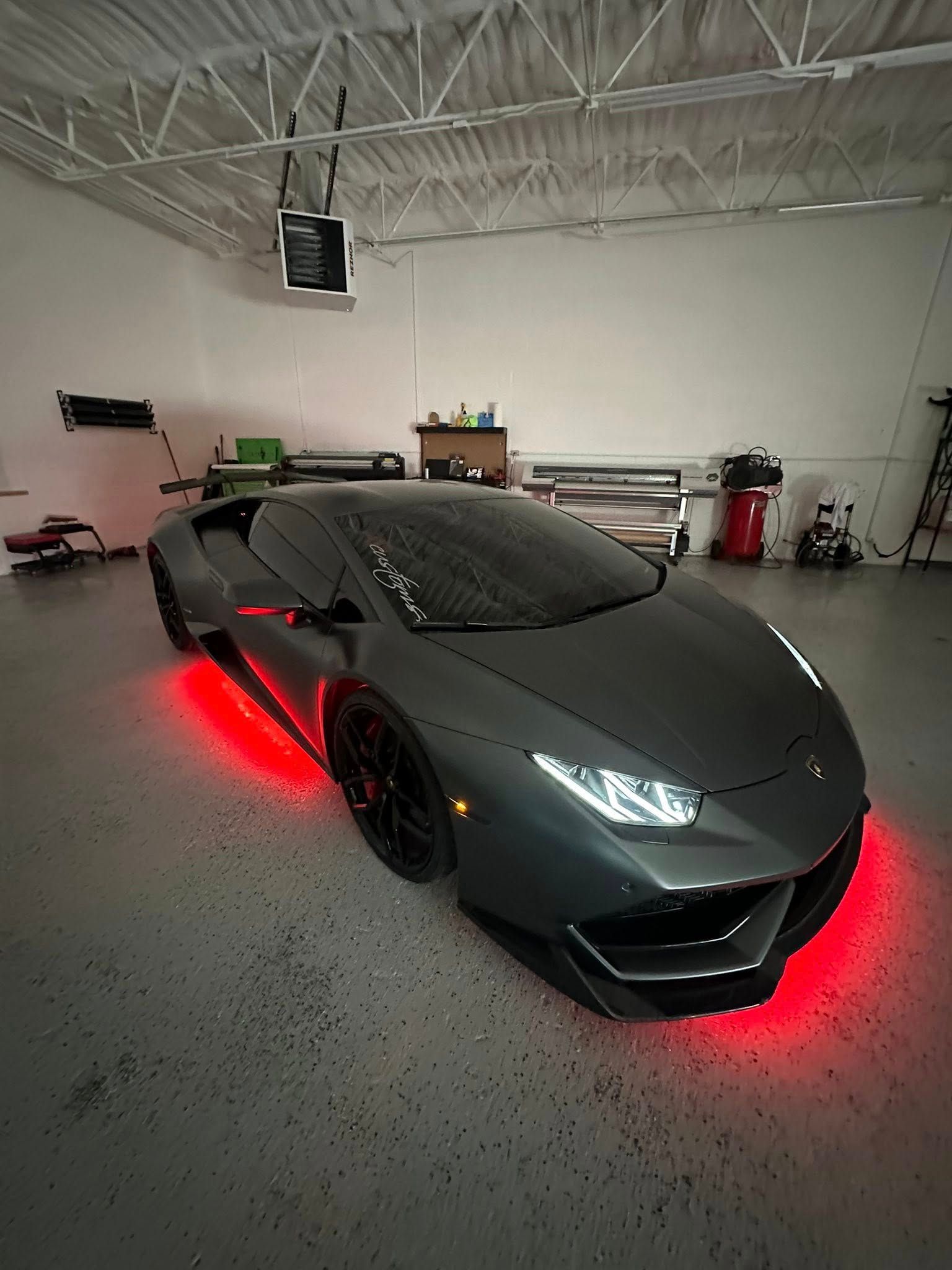 Woman in straw hat smiles, holding wine glass near a lake.