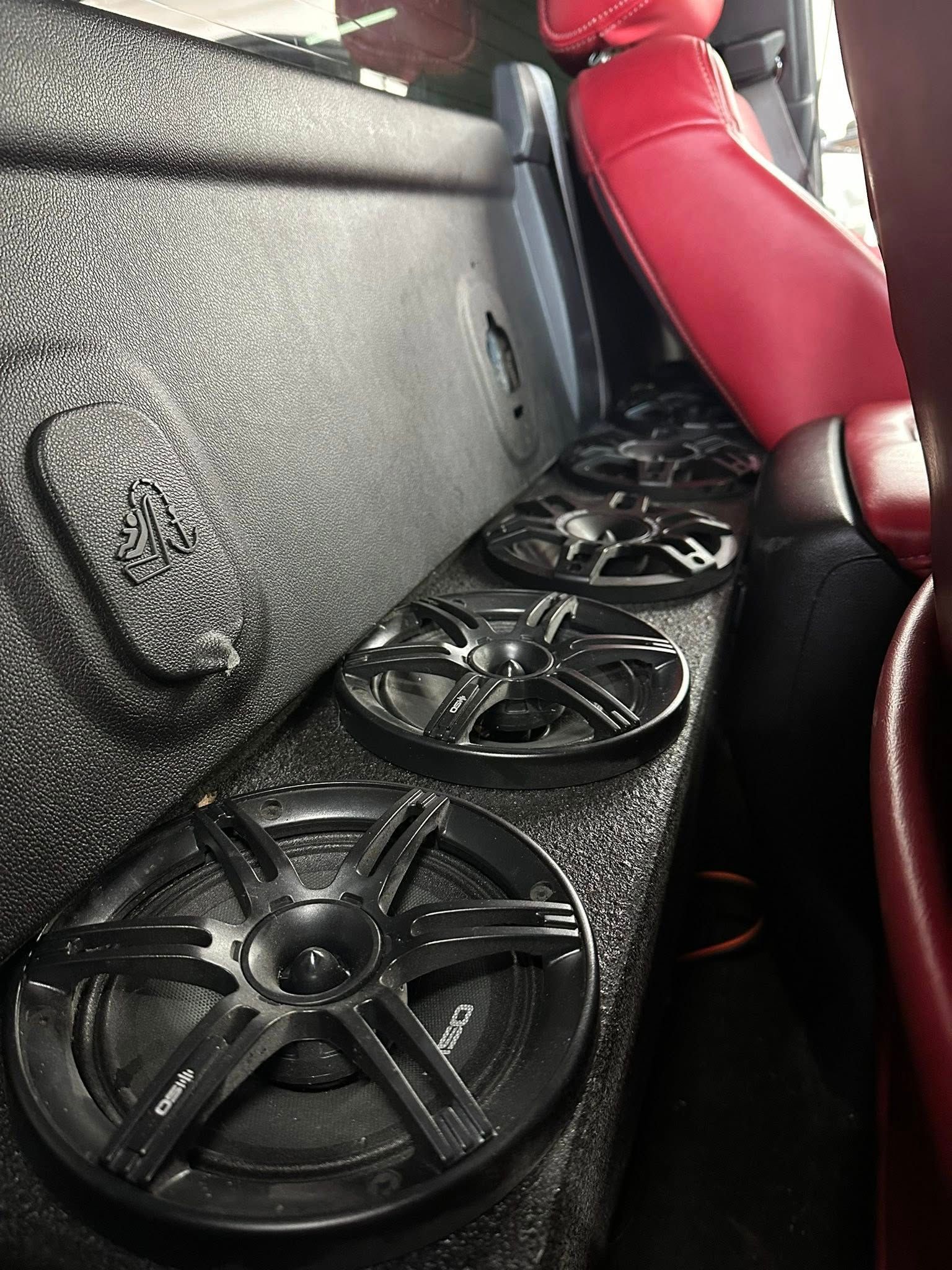 Woman in straw hat smiles, holding wine glass near a lake.