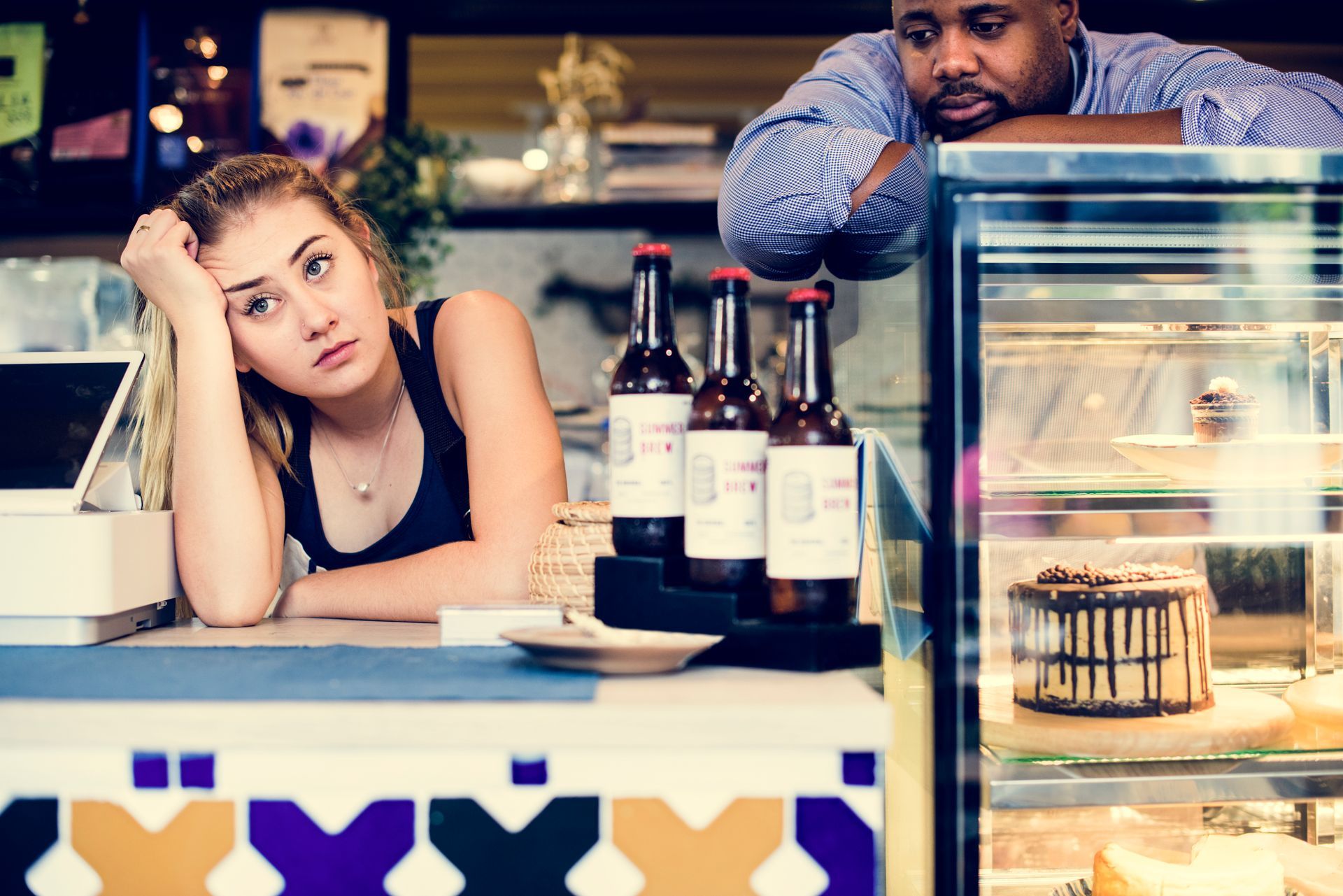 A man and a woman are standing in front of a display case in a restaurant, suffering hidden costs of ignoring content marketing.