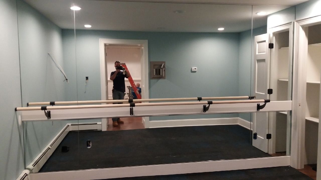 A man is standing in front of a mirror in a room.