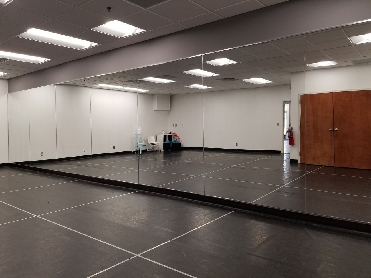An empty dance studio with a large mirror on the wall