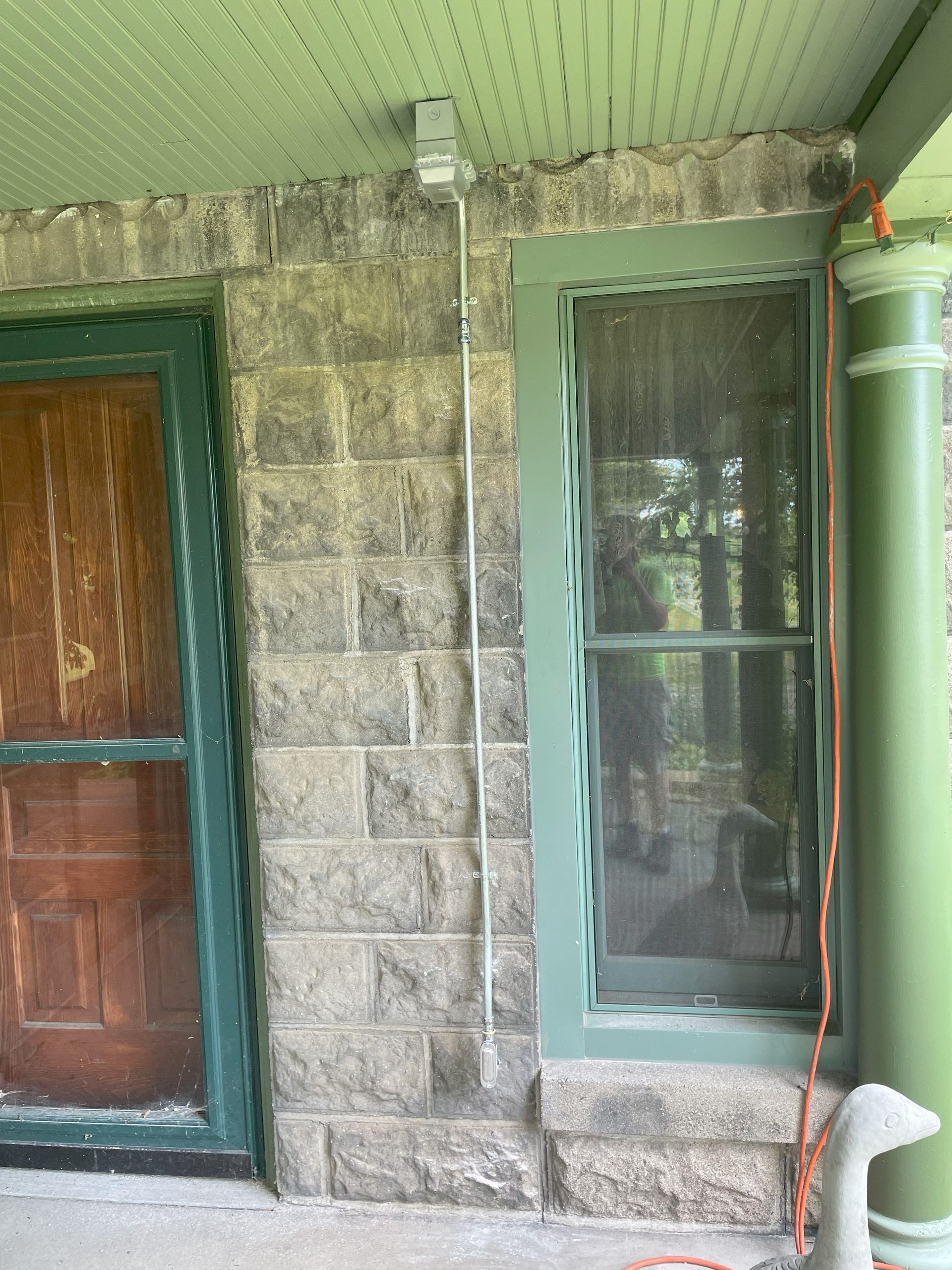 A brick building with a green door and a window.