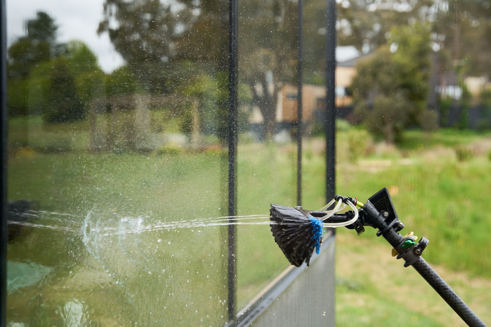 A person is cleaning a window with a brush.