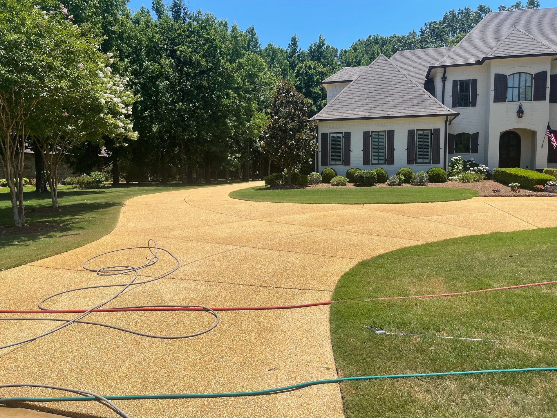 A large white house with a large driveway in front of it.