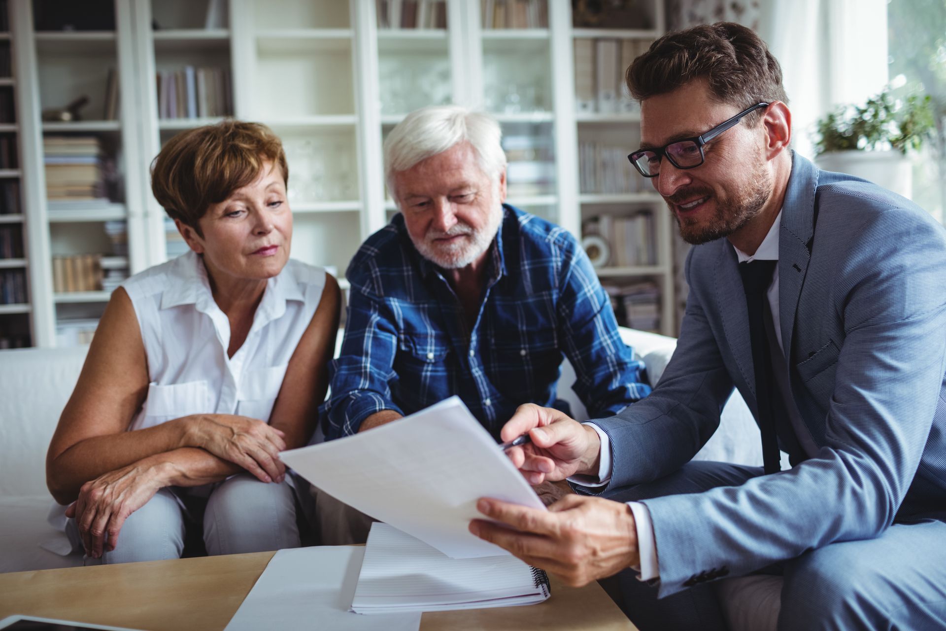 Advisor reviewing documents with two people during a retirement planning meeting. Advisor reviewing documents with two people during a retirement planning meeting.
