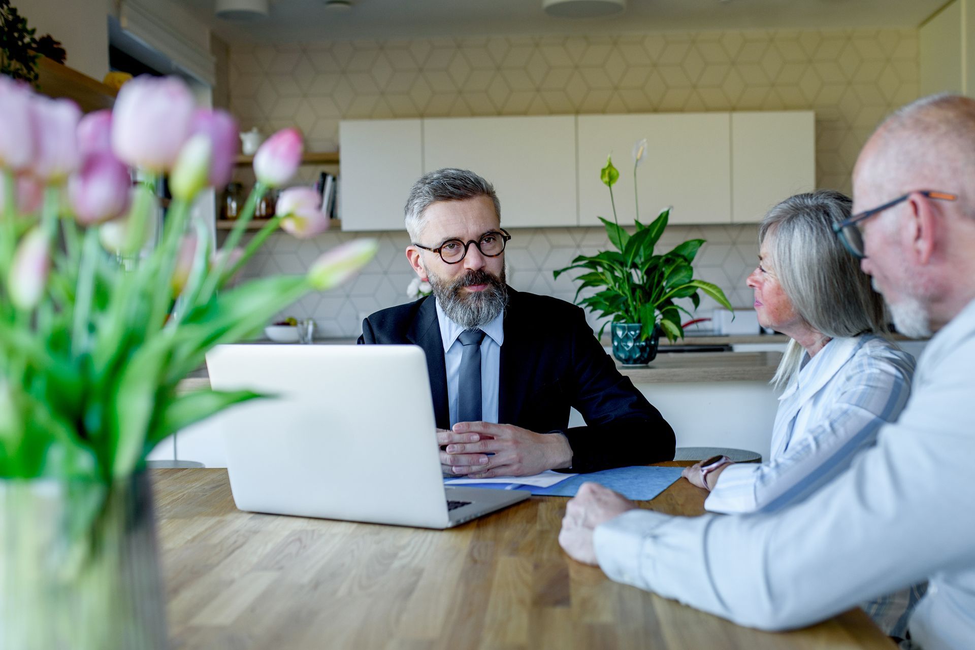 Elderly couple talking with financial advisor about budget and investments.