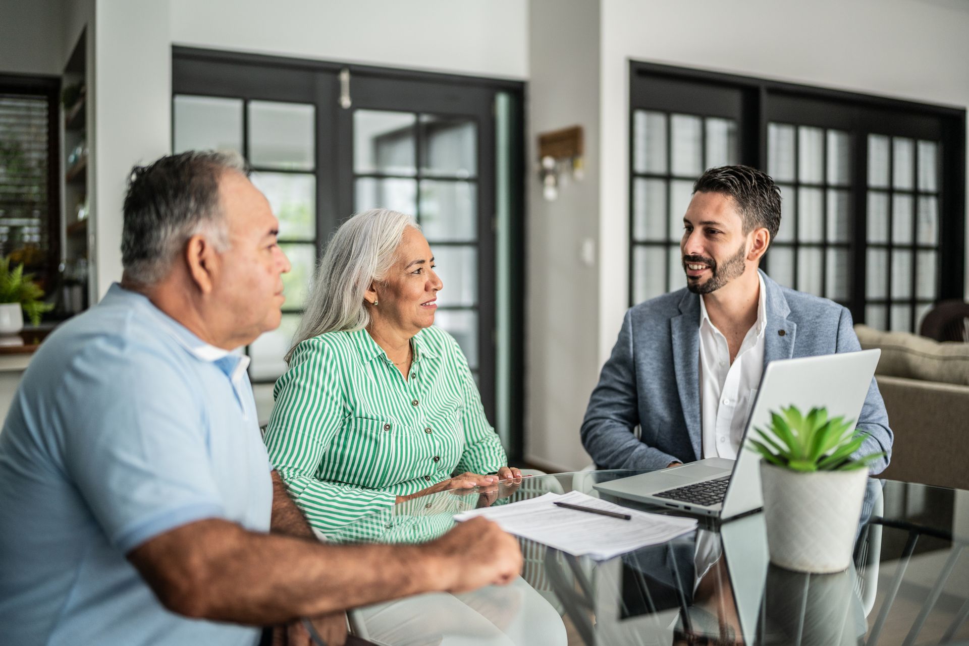 A financial advisor is having a meeting with a senior couple at home.