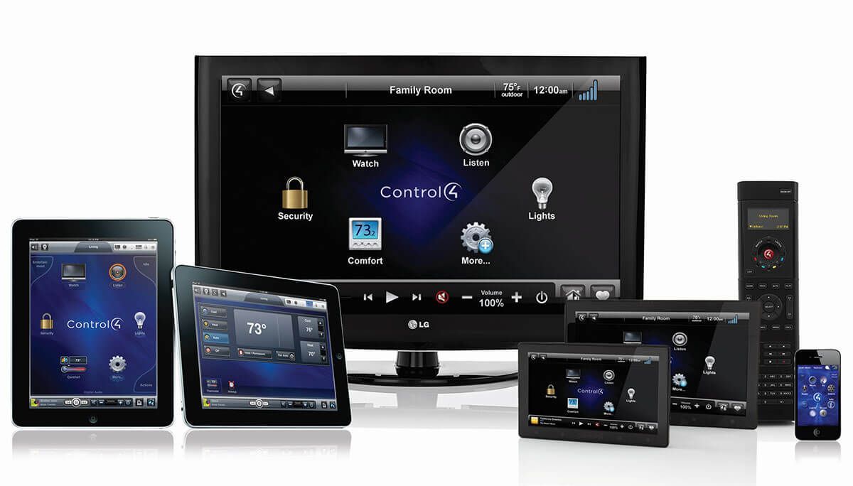 A display of multiple black smart home control devices: tablets, TV, phone, and remotes.