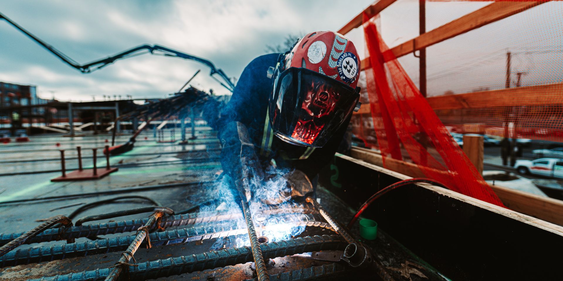 A construction worker welding metal at a construction site.