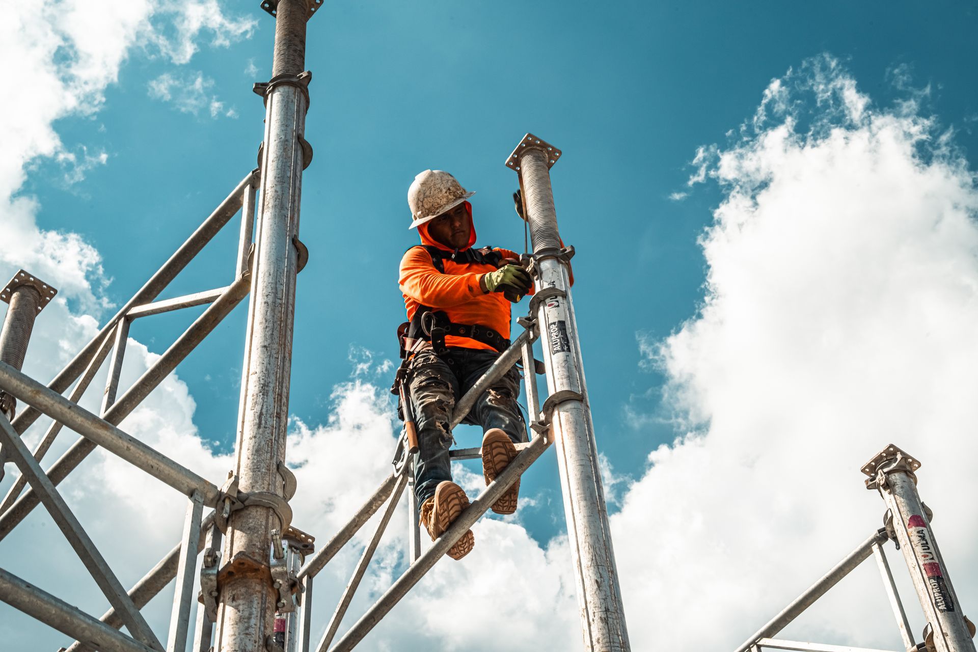 Person adjusting a professional video camera in a dim hallway.