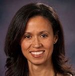 A woman with long dark hair is smiling for the camera.